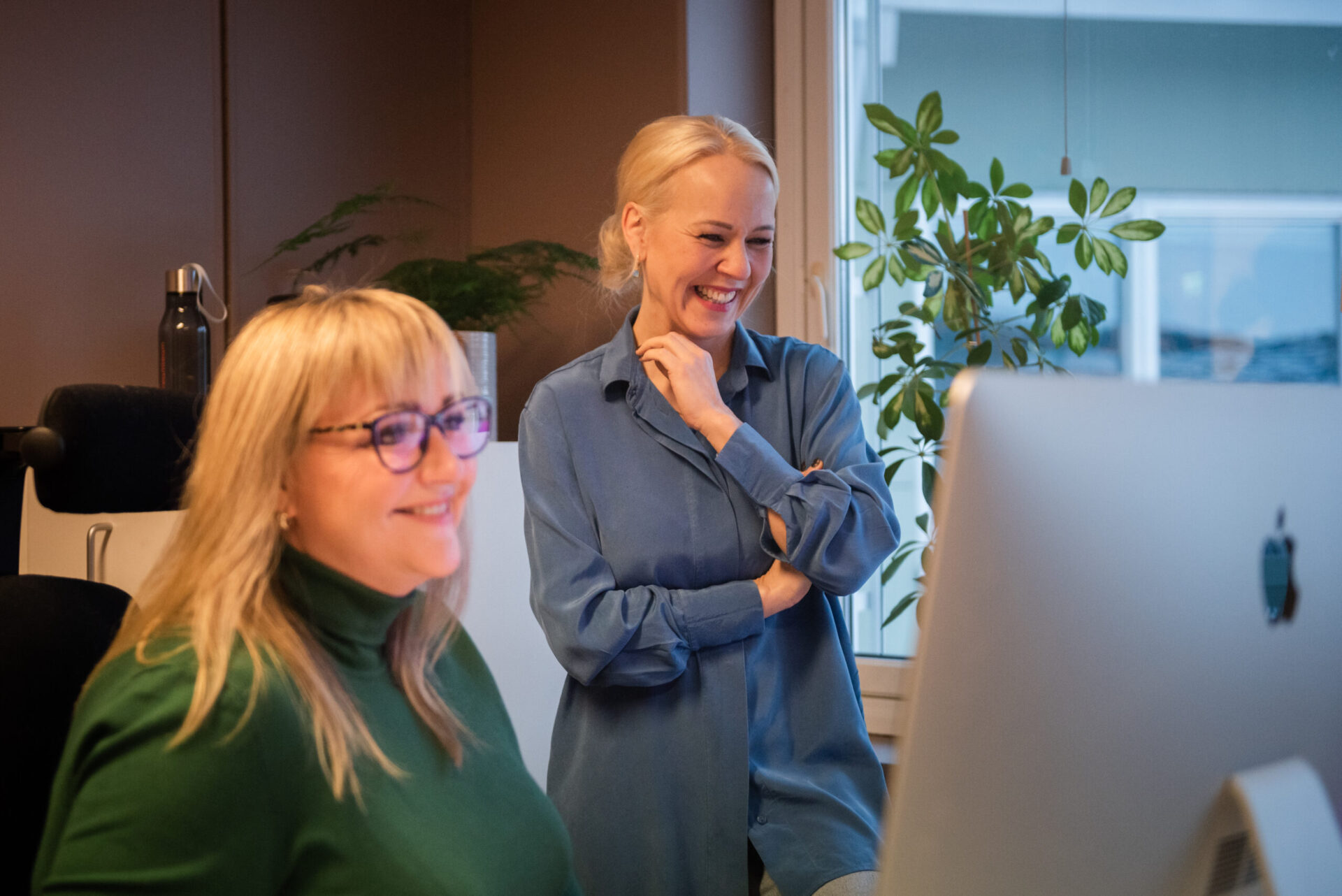 To kvinner som jobber på kontor og ser på dataskjerm